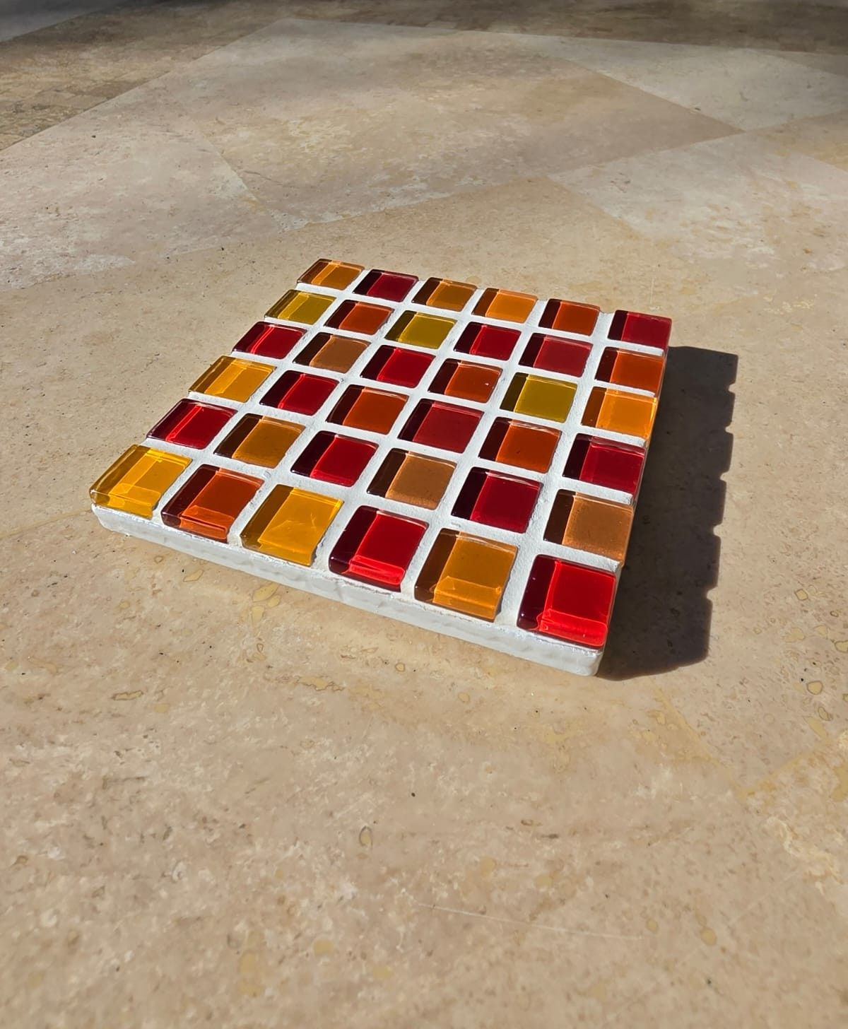 Fire coaster, red, orange and amber glass tiles on travertine