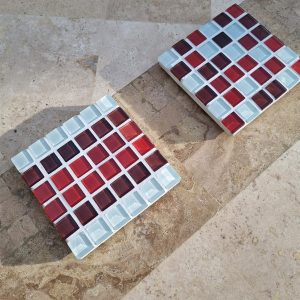 Lamington coaster, white and raspberry red glass tiles in the sun, with the Lamington Smash colourway behind