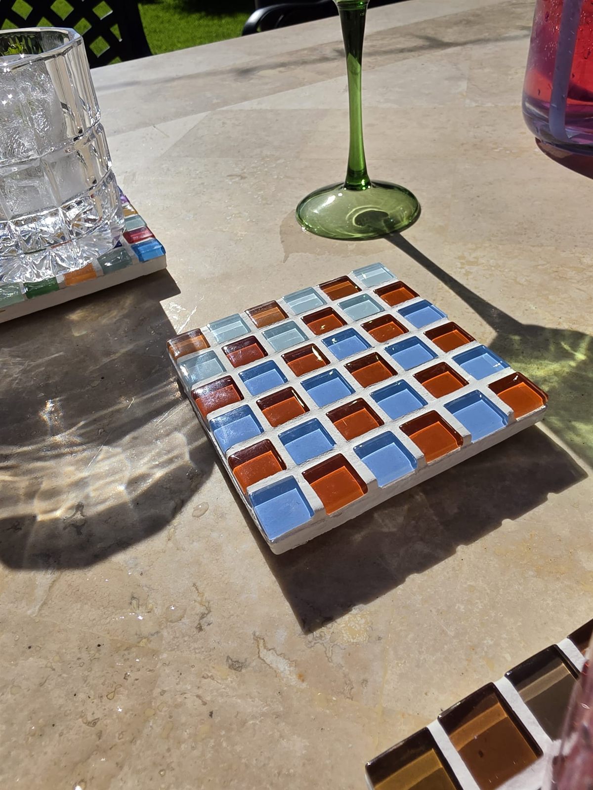 Shrimp coaster, blue, orange and warm glass tiles on travertine