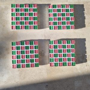 Four Watermelon coasters, pink and green glass tiles, on travertine