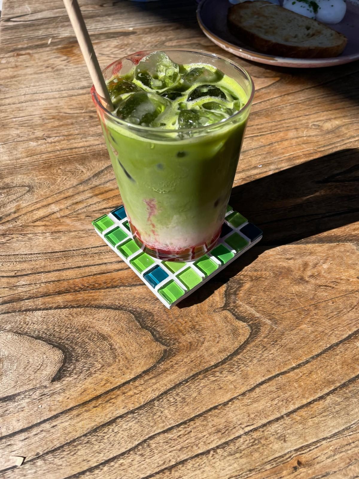 Iced matcha on a Spanish Moss glass coaster on a wooden table